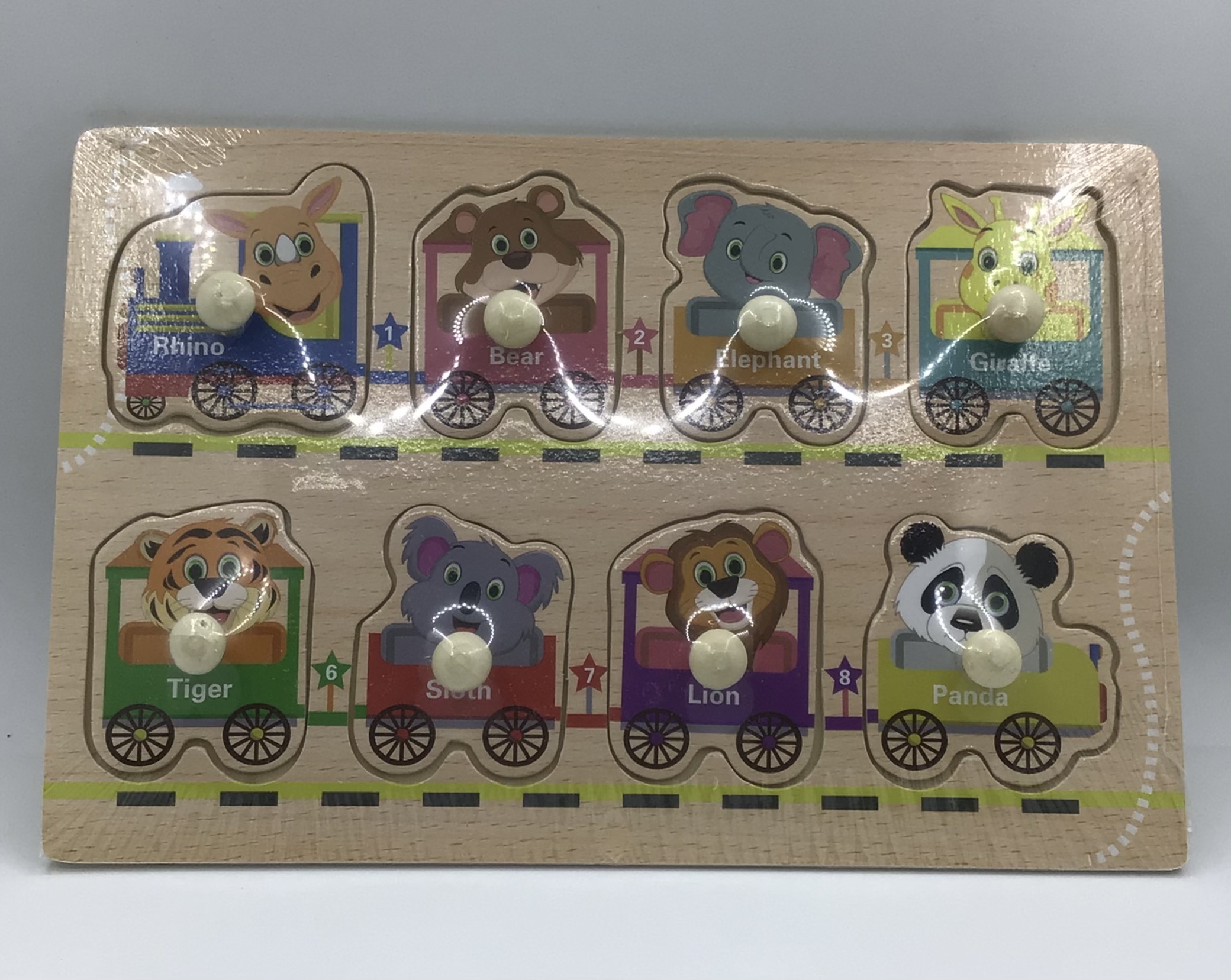 Puzzle din lemn cu pioneze având ca tematică trenuleț cu vagoane cu animăluțe sălbatice un joc indicat copiilor de peste trei ani